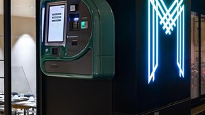 Ein moderner, gut beleuchteter Raum mit einer großen, leuchtenden Neonreklame und einer digitalen Bezahldomäne.