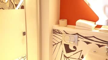 Baño con ducha, inodoro y lavamanos.