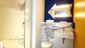 Ein Badezimmer mit Dusche, Toilette, Waschbecken und Spiegel.
