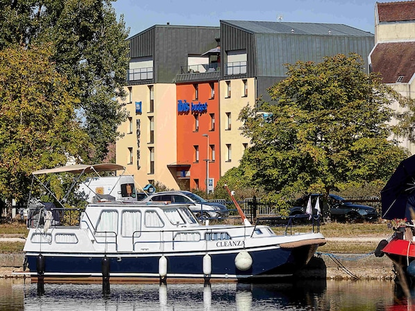 Ein Boot liegt in einer Marina vor einem Gebäude.