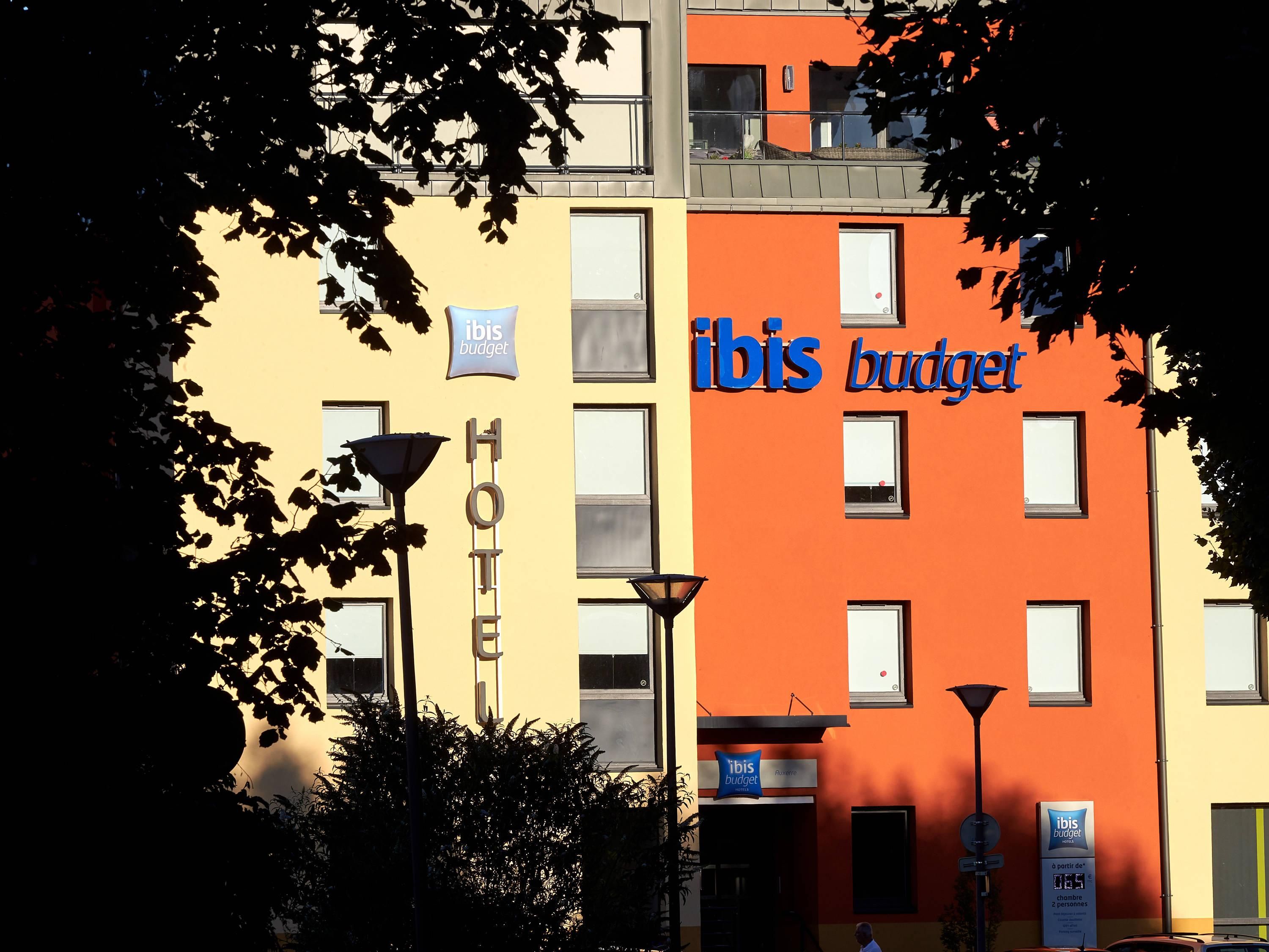 Een hotel met 'ibis budget'-aanduiding, een 'HOTEL'-bord en een 'RUSIA'-bord dat een Russische locatie aangeeft.