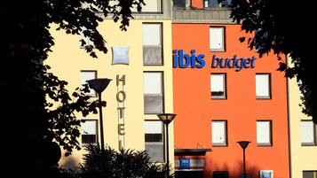 Een hotel met 'ibis budget'-aanduiding, een 'HOTEL'-bord en een 'RUSIA'-bord dat een Russische locatie aangeeft.