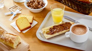 A breakfast tray with croissants, a glass of orange juice, a slice of cake, a sandwich with chocolate spread, and a cup of coffee. - Ibis Budget Auxerre Centre (Auxerre)