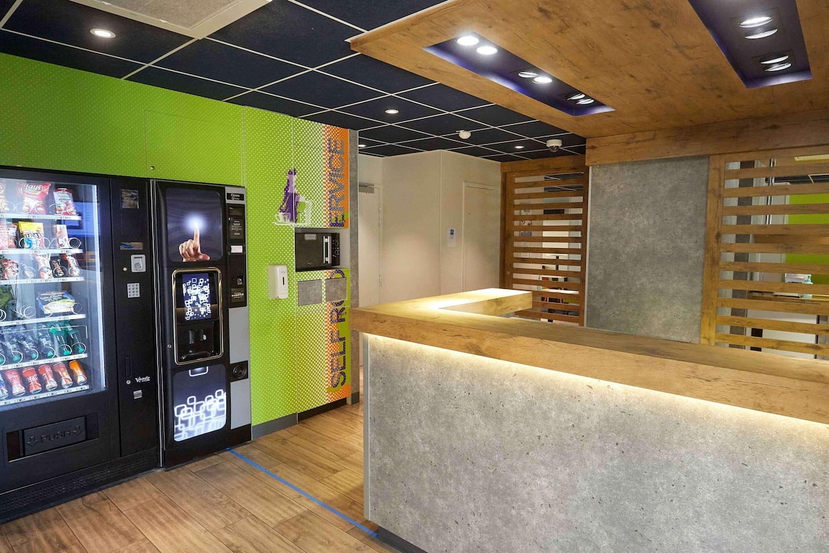 A modern interior with a vending machine, a counter, and a wooden ceiling.