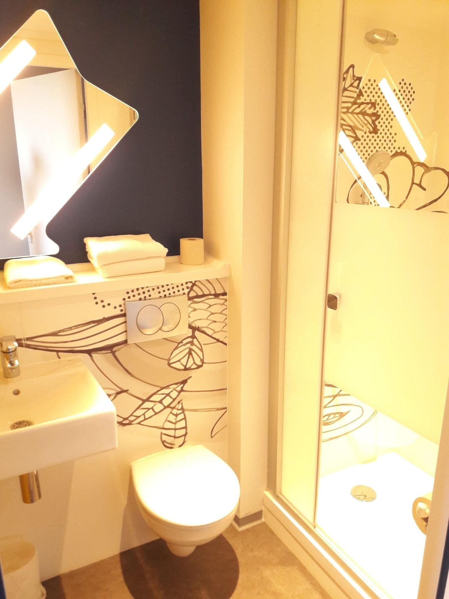 Een badkamer met toilet, wastafel en douche.