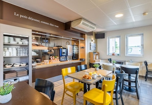 A modern cafe with a breakfast bar, yellow chairs, and a variety of breakfast items. - B&B Hôtel Lyon Saint-bonnet Mi-plaine (Saint-Bonnet-de-Mure)