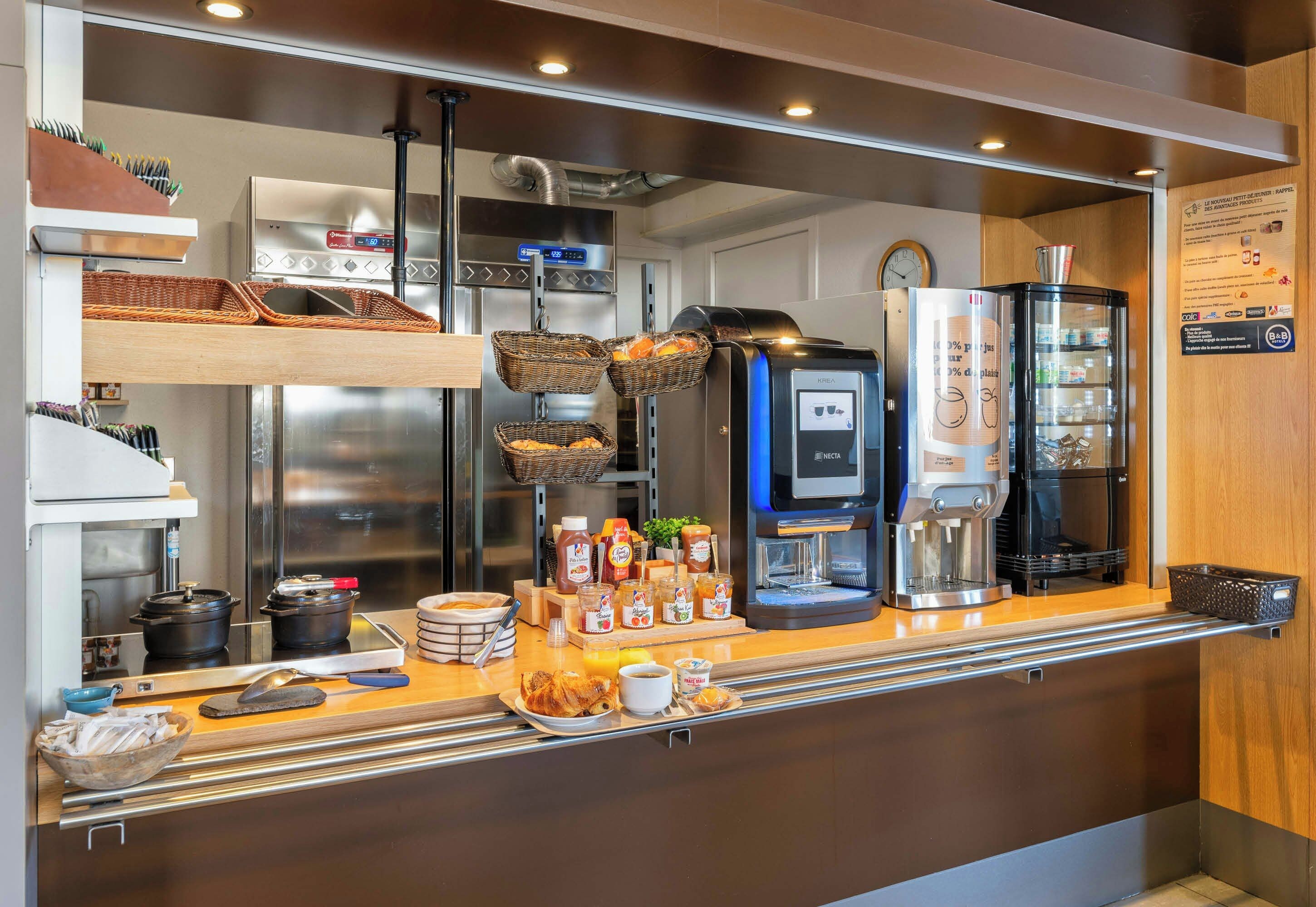 A coffee station with a coffee machine, condiment dispensers, and a refrigerator.