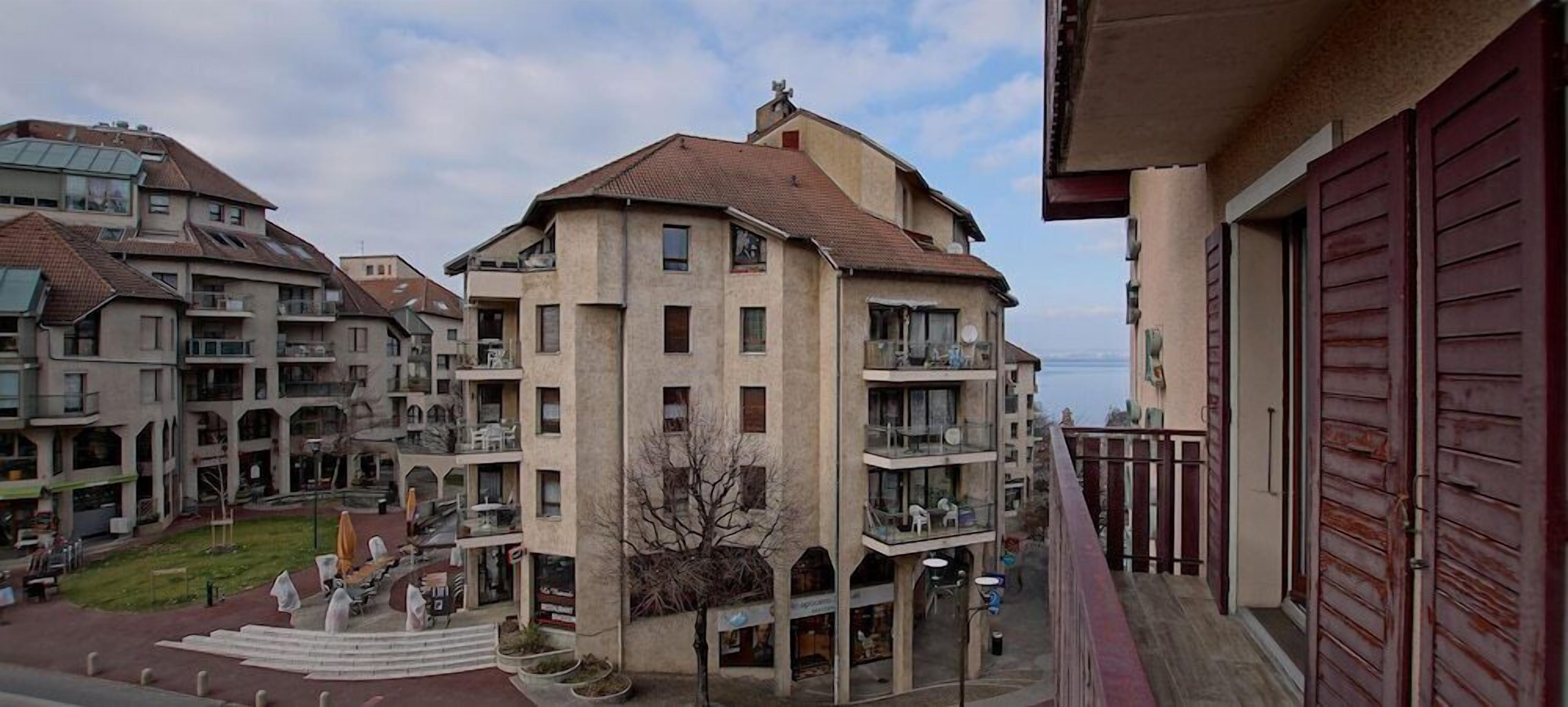 Un immeuble résidentiel à plusieurs étages, doté de balcons, d’une cour intérieure et offrant une vue sur la mer.
