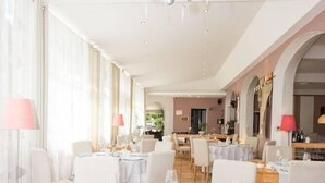 A dining area with round tables set for a meal, featuring white tablecloths, plates, and cutlery. - La Magnanerie (Aubignosc)
