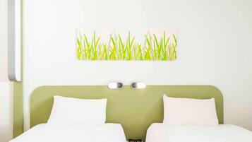 Une chambre d’hôtel avec deux lits, une tête de lit verte, une lampe fixée au mur et une décoration murale représentant de l’herbe.