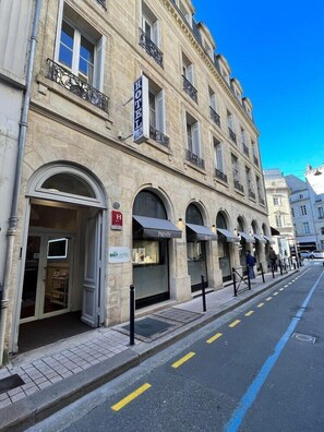 A hotel with a classic facade, multiple balconies, and a prominent sign indicating it is a hotel. - Hotel De France (Bordeaux)