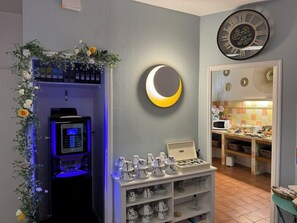 A room with a coffee station, a clock, and a wall-mounted mirror. - Hotel De France (Bordeaux)