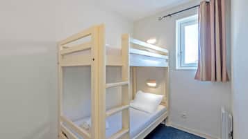A bunk bed room with a window and a curtain.