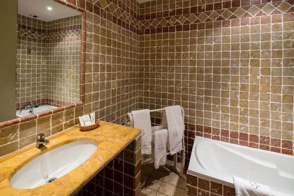 A bathroom with a sink, bathtub, and tiled walls. - Relais Du Silence Le Clos De Pradines (Saint-Quentin-la-Poterie)