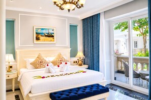A hotel room with a large bed, a chandelier, a painting, and a view of the outdoors. - Lan Rung Phuoc Hai Resort And Spa (Long Dat)