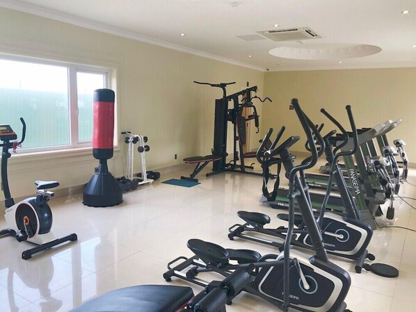 A gym with various exercise equipment including treadmills, stationary bikes, and weight machines. - Lan Rung Phuoc Hai Resort And Spa (Long Dat)