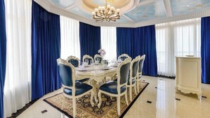 A formal dining room with a round table, blue upholstered chairs, and a chandelier. - Lan Rung Phuoc Hai Resort And Spa (Long Dat)