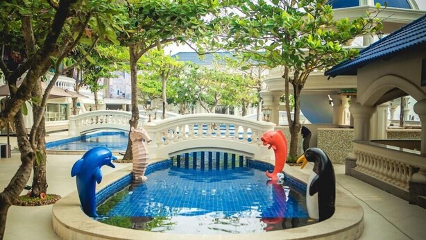 A pool area with decorative sculptures of a dolphin, penguin, and flamingo. - Lan Rung Phuoc Hai Resort And Spa (Long Dat)