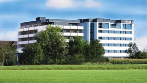 A modern hotel building with multiple floors, a flat roof, and a sign indicating it is a hotel. - Seligweiler (Elchingen)