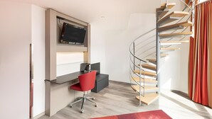 Una habitación moderna con escritorio, silla y una escalera de caracol.