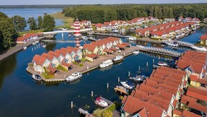 A marina with houses and boats, surrounded by water and trees. - Precise Resort Hafendorf Rheinsberg (Rheinsberg)
