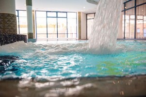 Una fuente de agua con cascada en un espacio interior bien iluminado.