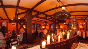 A bar area with wooden beams, candles, and patrons. - Eisenacher Hof (Eisenach)