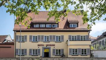 Ein zweistöckiges Gebäude mit einem Schild, auf dem „HOTEL SEEROSE“ steht.
