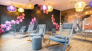 A spa room with modern chairs, a wooden floor, and decorative wall panels. - A-ja Bad Saarow. Das Resort (Bad Saarow)
