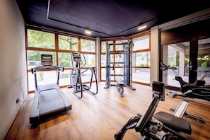 Une salle de sport équipée de tapis de course, de vélos elliptiques et de matériel de musculation.