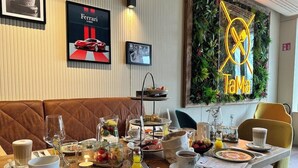 A dining area with a table set for breakfast, including plates, cups, and a variety of food items.