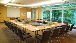 A conference room with a long table, chairs, a whiteboard, and a projector screen. - Ringhotel Waldhotel Heiligenhaus (Heiligenhaus)