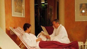 A spa room with two reclining chairs, a massage table, and a massage therapist. - Ringhotel Waldhotel Heiligenhaus (Heiligenhaus)