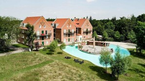 Un hotel con piscina, varias edificaciones y abundante vegetación.