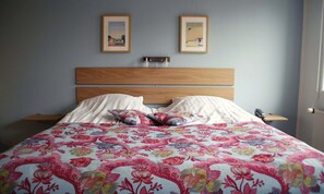 A bedroom with a wooden headboard, two bedside tables, a floral bedspread, and two framed pictures on the wall. - Aalbaek Badehotel, Sure Hotel Collection by Best Western (Aalbaek)