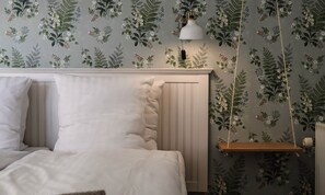 A bedroom with a bed, white bedding, a hanging lamp, and a wooden shelf. - Aalbaek Badehotel, Sure Hotel Collection by Best Western (Aalbaek)