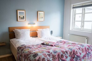 A hotel room with a bed, two wall-mounted picture frames, a bedside table, and a window. - Aalbaek Badehotel, Sure Hotel Collection by Best Western (Aalbaek)