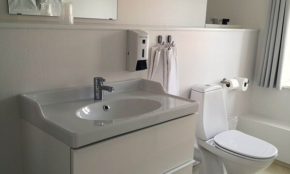 A modern bathroom with a sink, mirror, and toilet. - Aalbaek Badehotel, Sure Hotel Collection by Best Western (Aalbaek)