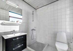 Un baño moderno con ducha, inodoro y tocador.