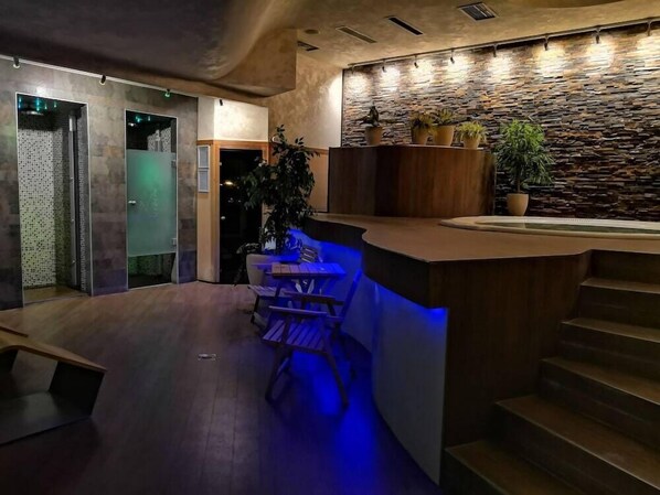 A modern interior with a wooden reception desk, a stone wall, and a staircase. - Alexandar (Novi Sad)