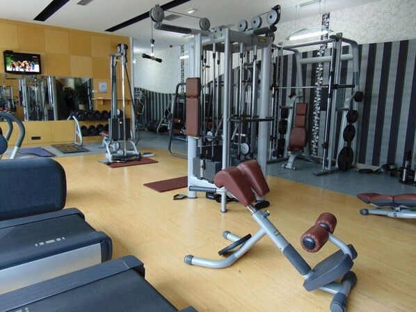 A gym with various exercise equipment, including weight machines and free weights. - Alexandar (Novi Sad)