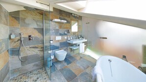A modern bathroom with a glass-enclosed shower, a freestanding bathtub, and a large mirror above the sink. - Boutique Business Hotel La Tureta (Bellinzona)