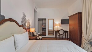 A hotel room with a large bed, bedside table with a lamp, a desk with a chair, a wardrobe, and a mirror on the wall. - Boutique Business Hotel La Tureta (Bellinzona)