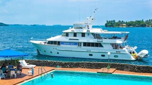 Un yate grande amarrado en un puerto deportivo, con piscina y zona de descanso.