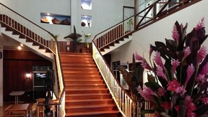 Una imponente escalera de madera con barandillas blancas que conduce a un piso superior.