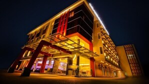 Um hotel moderno com entrada destacada e área externa coberta.