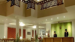 A spacious lobby with a reception desk, seating area, and decorative elements. - Club Mahindra Chumbi (Gyalshing)