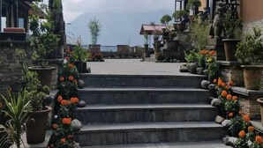 A stone staircase leading to a building with a mountain view in the background. - Club Mahindra Chumbi (Gyalshing)