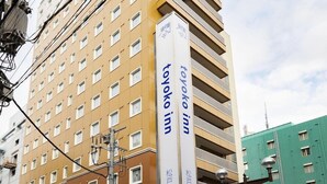 Un immeuble à plusieurs étages, sur lequel on peut voir une enseigne indiquant « Toyako Inn », ce qui signifie qu’il s’agit d’un hôtel.
