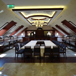 A large conference room with a long table, chairs, a chandelier, and a ceiling with recessed lighting. - Centrum Hotel Debrecen (Debrecen)